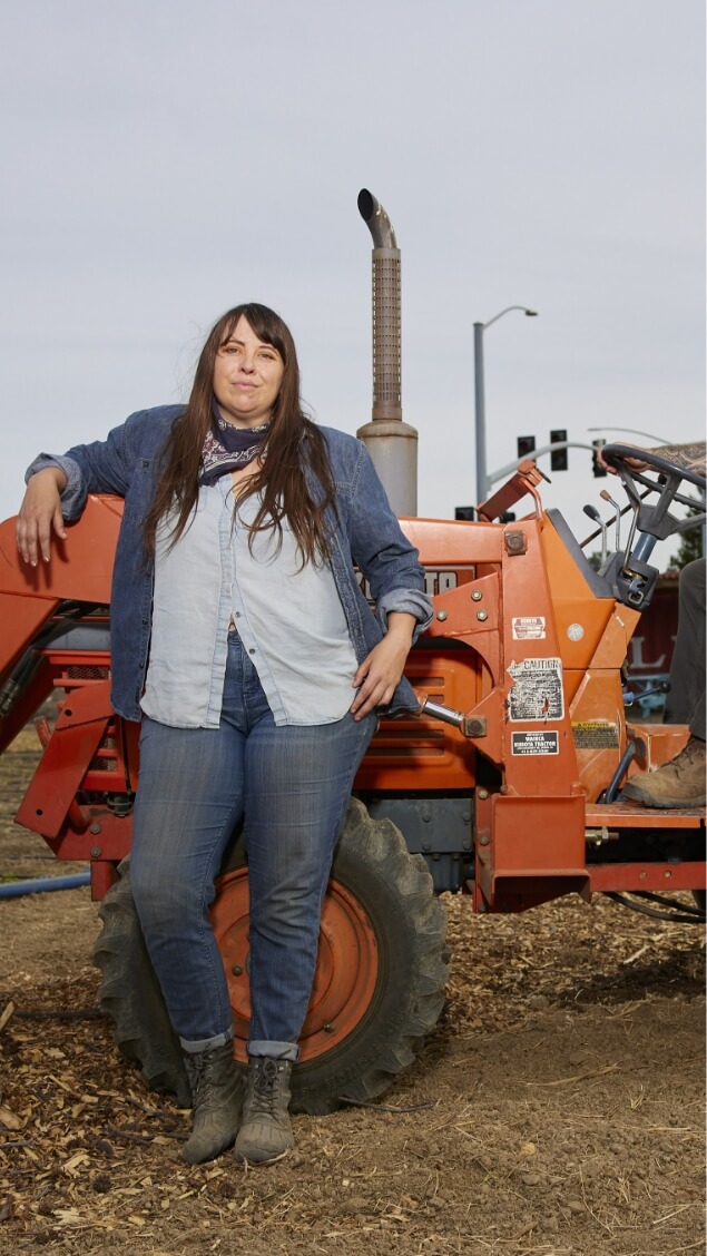 Woman leaning against a tractor
